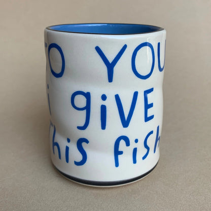 White mug with blue text on a beige background