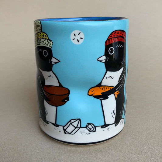 Cylindrical mug with penguin design on a beige background