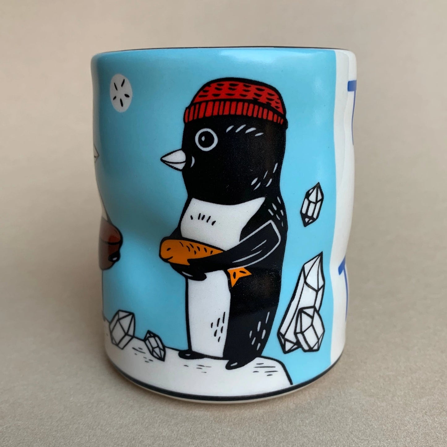 Mug with a penguin design on a light gray background