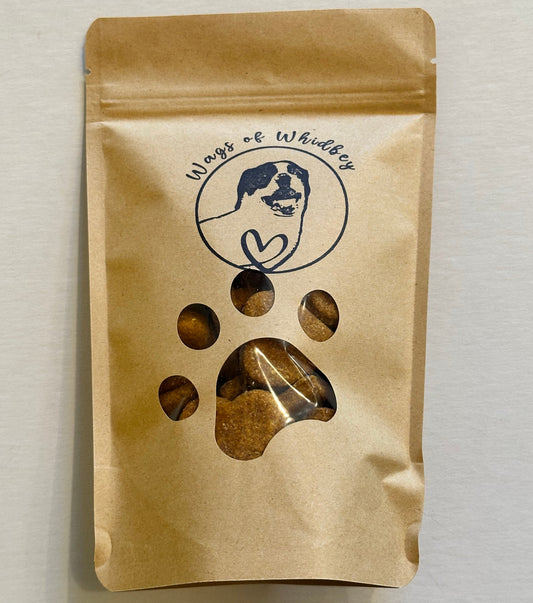 Kraft paper packaging with a paw print cut-out showing the treats inside, and a stamp of a dog with the words 'Wags of Whidbey'